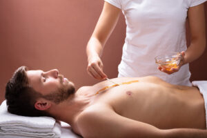 Therapist Applying Wax On Man's Chest
